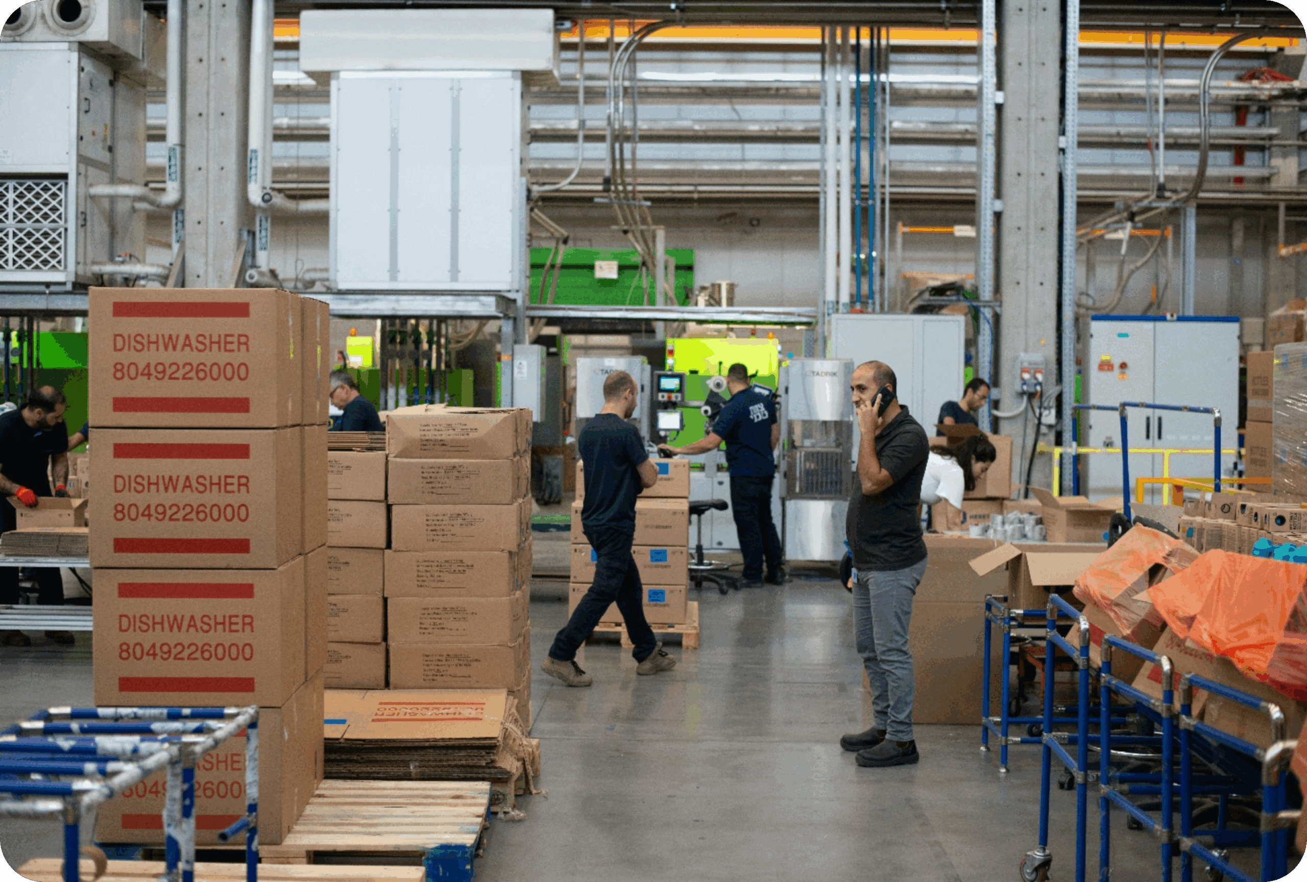 Man in gray shirt standing beside brown cardboard boxes
