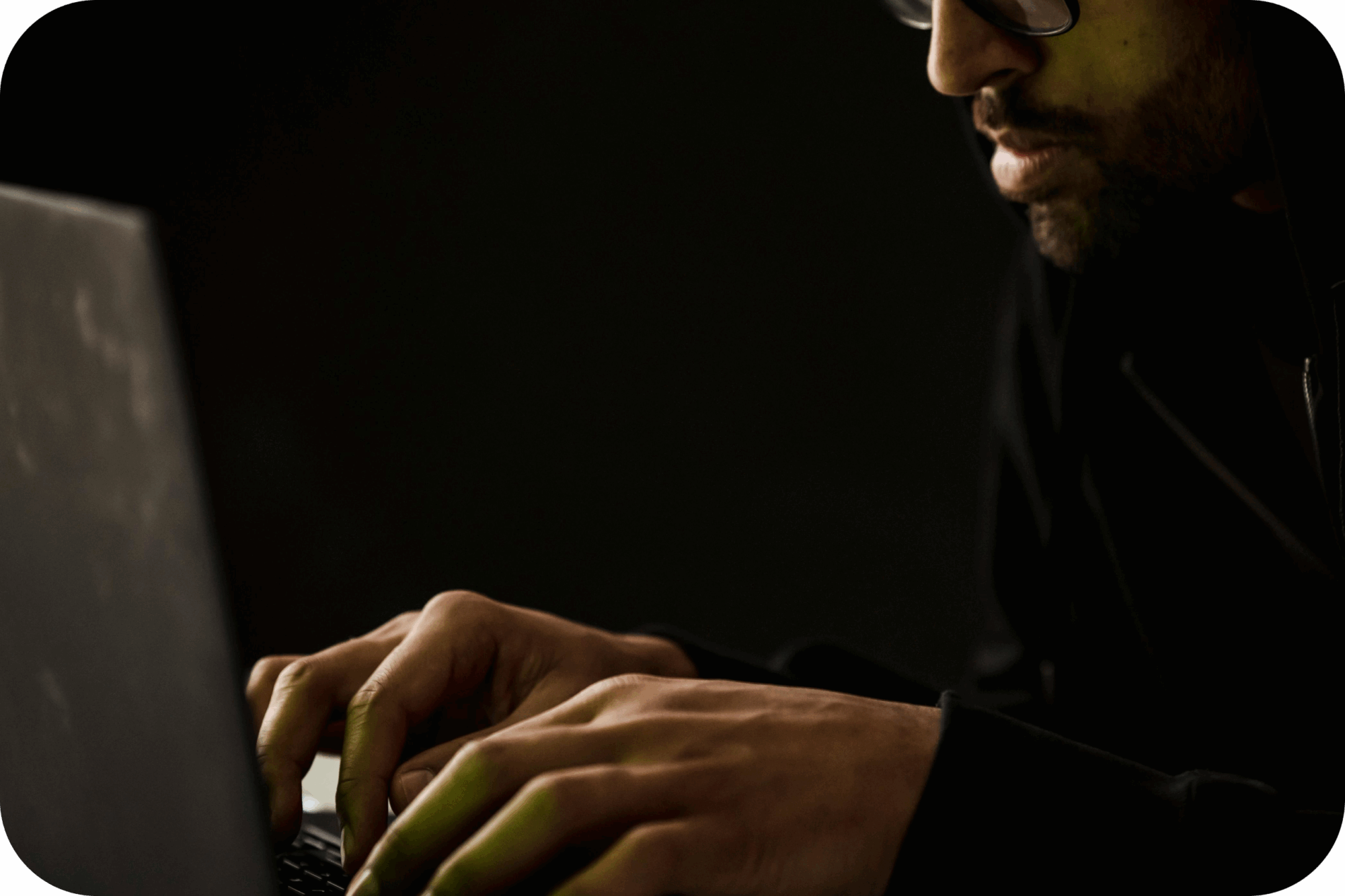 Cybersecurity professional working on a laptop in a secure environment, performing network monitoring and data protection tasks to prevent cyber threats.