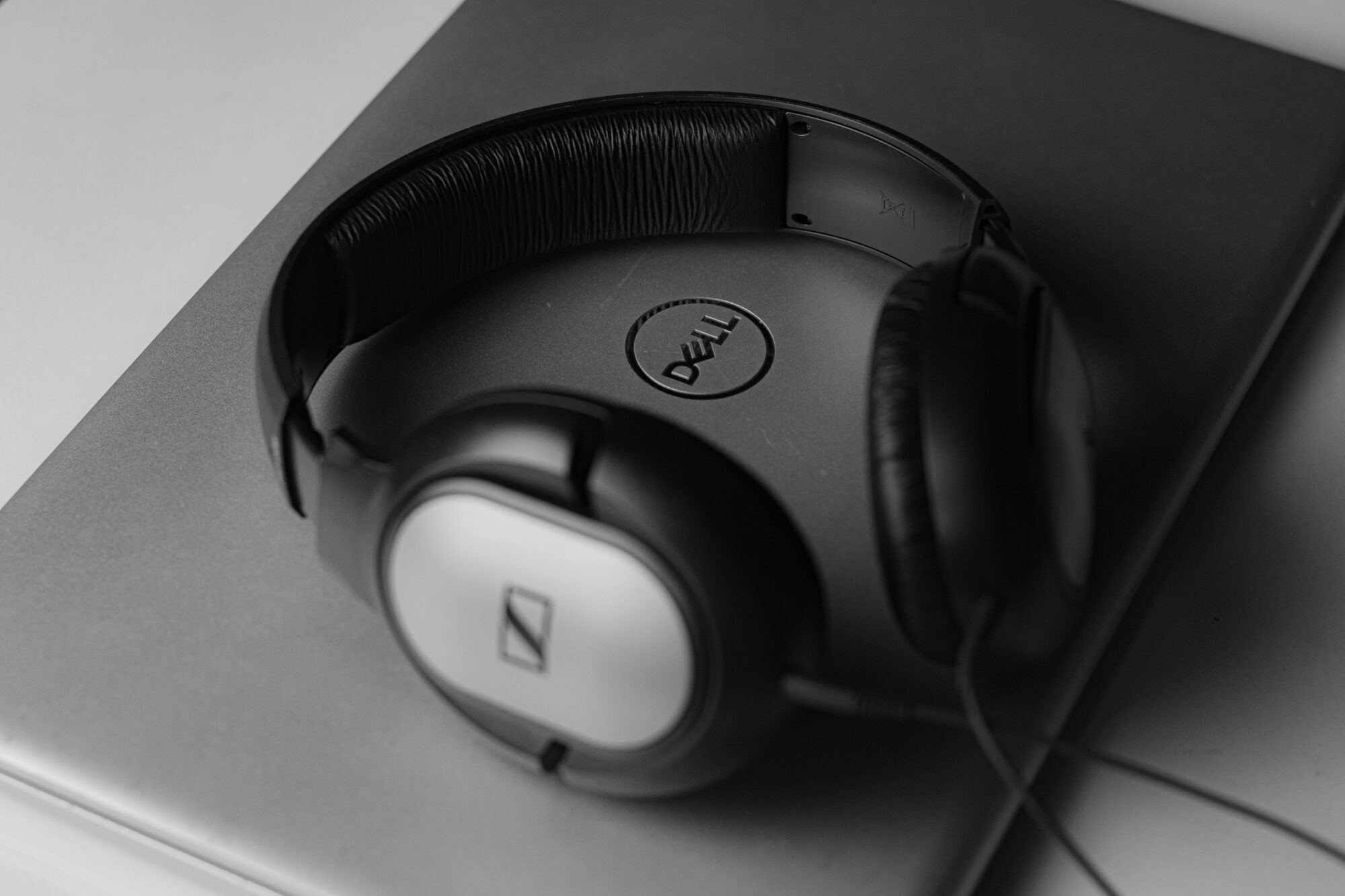 Headphones on top of a laptop showing the Dell logo in the middle
