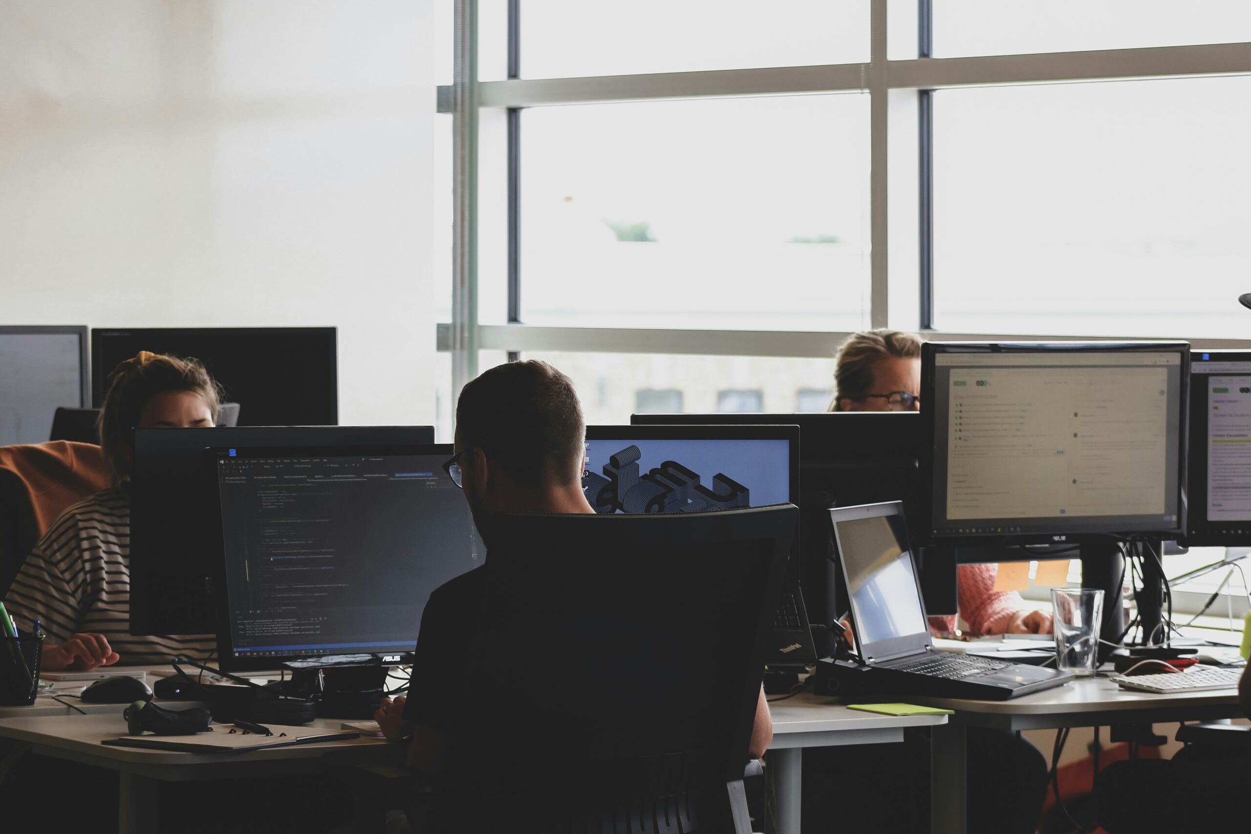 Team members working on their computers in open office