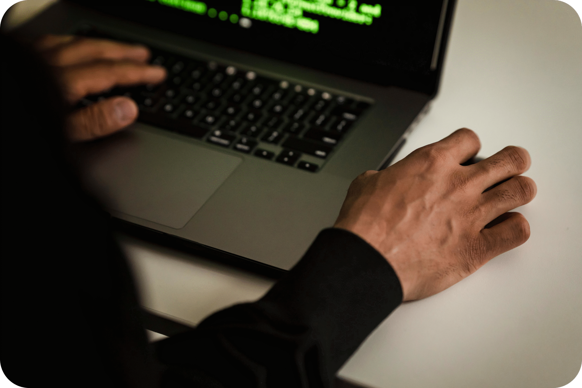 Hands using laptop with green code on screen