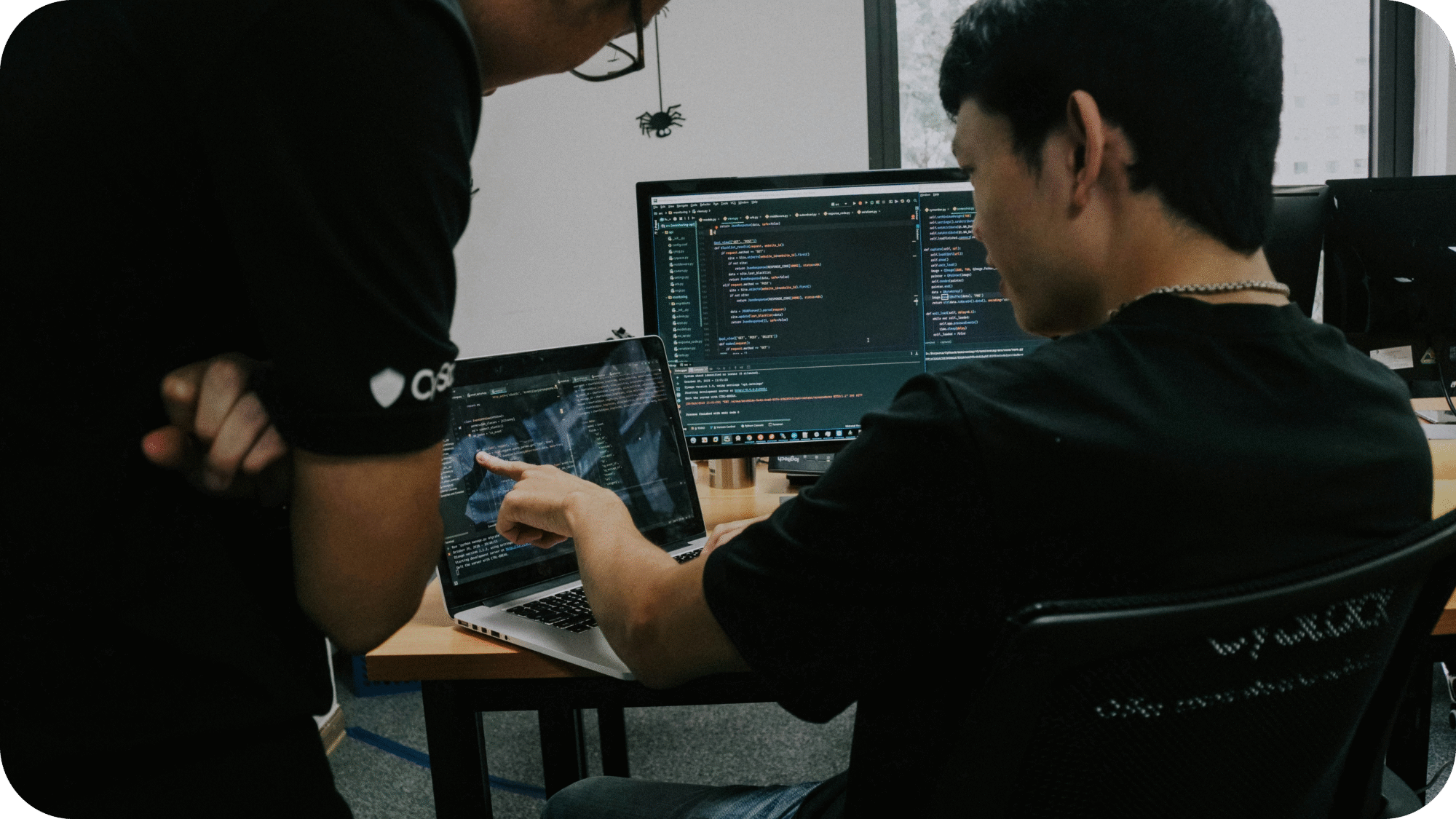 Two people discussing content on a laptop screen